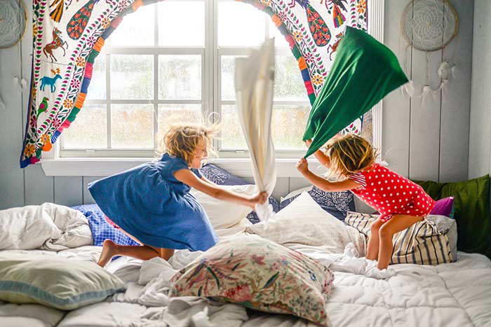 girls having pillow in front of hurricane windows